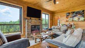 a living room with a fireplace and a tv at Lions Landing by AvantStay Sleeps 18 Hot Tub Game Room Views Near Pigeon Forge in Sevierville