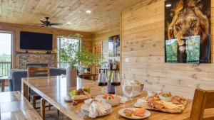 a dining room with a table with food on it at Lions Landing by AvantStay Sleeps 18 Hot Tub Game Room Views Near Pigeon Forge in Sevierville