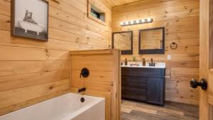a bathroom with a tub and a sink at Lions Landing by AvantStay Sleeps 18 Hot Tub Game Room Views Near Pigeon Forge in Sevierville +42 photos