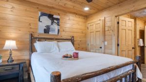 a bedroom with a bed with a bowl of fruit on it at Lions Landing by AvantStay Sleeps 18 Hot Tub Game Room Views Near Pigeon Forge in Sevierville