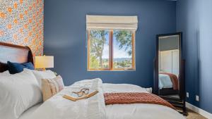 a bedroom with blue walls and a bed with a mirror at Wine Country Escape w Views Wine Cellar Gym Caterina Dusi Vineyard by AvantStay in Paso Robles