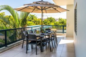 a table with chairs and an umbrella on a balcony at Aquaville Dorado Moderna Villa 5 in Dorado