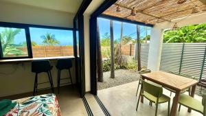 a dining room with a table and chairs and a window at Lodge Palmiste, Escale tropicale in Étang-Salé