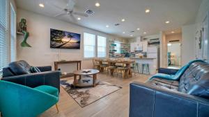 un soggiorno con due divani blu e un tavolo di 2 Homes in Old Town by AvantStay Sleeps 19 Pool Newly Built Walk to Eats Music More a Port Aransas