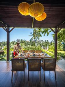 a man preparing food on a table in a house at Little Oasis - An Eco Friendly Hotel & Spa in Hoi An