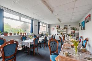 a dining room with tables and chairs in a restaurant at Westbrook Lodge Guest House in Margate