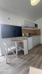 a kitchen with a white table and a table and a counter at SER4 studio avec WIFI et Parking à Saint-Etienne-Du-Rouvray in Saint-Étienne-du-Rouvray
