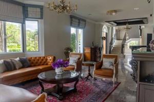 ein Wohnzimmer mit Sofa und Tisch in der Unterkunft Chateau de Luxi Khao Yai - ชาโตว์ เดอ ลูซี่ เขาใหญ่ in Mu Si