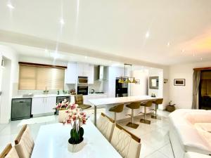 a kitchen and living room with a table and chairs at Zahara property in Windhoek