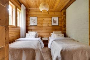 a bedroom with two beds in a log cabin at Tennihovi Cottage Hosted by Hygge Host in Jokela