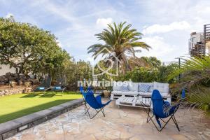 eine Terrasse mit blauen Stühlen und einem weißen Sofa in der Unterkunft Private Pool Villa, Bellavista by Nivariahost in Costa Del Silencio