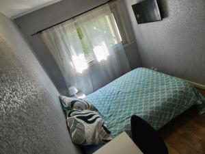 a small bedroom with a bed and a window at Chambre privée in Le Mée-sur-Seine