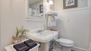 a white bathroom with a sink and a toilet at Luxury Wine Country Haven Vineyard Views Near Top Wineries Adelaida Farmhouse in Paso Robles +48 photos