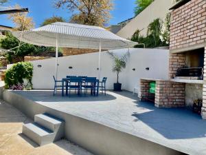 a table and chairs under an umbrella on a patio at Zahara property in Windhoek