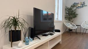 a living room with a television on a white table at Up Lavie DUX in Aveiro