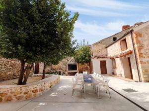 a table and chairs in front of a building at Alojamiento Turístico Casa Los Laureles in Segovia