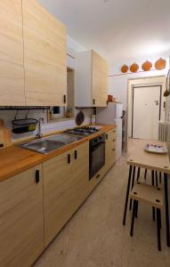 a kitchen with wooden cabinets and a sink and a table at Eagle & Dolphin Holiday Home in Taranto