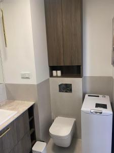 a small bathroom with a toilet and a sink at CozyNestApartament in Lublin