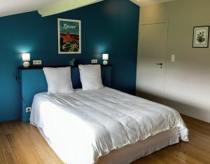 ein Schlafzimmer mit einem großen Bett mit einer blauen Wand in der Unterkunft Gîte trois étoiles, maison de campagne in Fiac + 5 Fotos