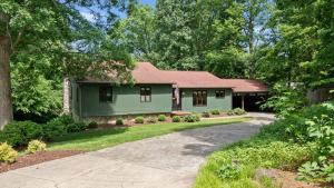 une maison verte avec une allée en face de celle-ci dans l'établissement Shady Daze: Waterfront Home w Deck Hot Tub Lake Views, à Sherrills Ford