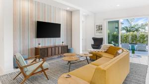 a living room with a couch and a tv at Lumen at Tahquitz: New Build with Pool Fire Pit Designer Interiors in Palm Springs