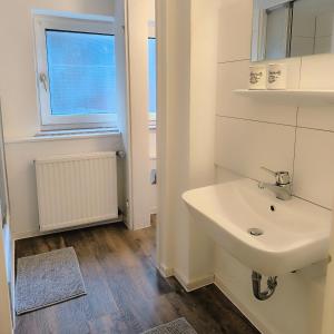 a white bathroom with a sink and a window at Apartment Amsterdam - Berlin in Lügde +7 photos