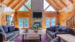 ein Wohnzimmer mit Ledersofas und einem Kamin in der Unterkunft Big Bear Cove by AvantStay Hot Tub Game Room Fireplace Smoky Mtn Views in Sevierville