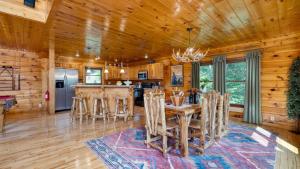 ein Esszimmer und eine Küche in einer Blockhütte in der Unterkunft Big Bear Cove by AvantStay Hot Tub Game Room Fireplace Smoky Mtn Views in Sevierville