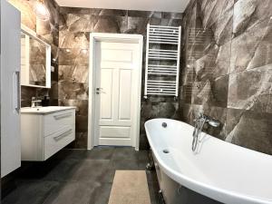a bathroom with a white tub and a sink at Przedmiejska Apartment - Self check-in 20h in Wrocław