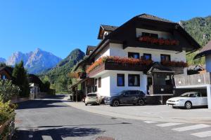 a building with cars parked in front of it on a street at Apartments Rozle in Kranjska Gora