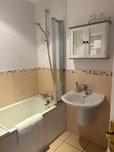 a bathroom with a bath tub and a sink at Coastal Comforts in Newcastle +7 photos