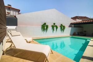 Una piscina con una pared con gente verde en ella. en WHome Luxurious Oeiras Stay with Private Pool, en Oeiras