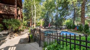a pool in a yard next to a fence at Aspen Hideaway by AvantStay Walk to Aspen Near Slopes Pool Hot Tub Access in Aspen