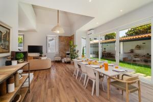 Un comedor y una sala de estar con mesa y sillas. en WHome Luxurious Oeiras Stay with Private Pool, en Oeiras
