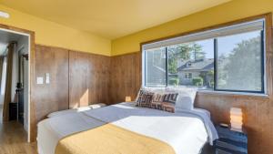 een slaapkamer met een bed en een groot raam bij Walk to Beach Shops Fireplace Patio Dining Firepit at Manzanita Ave. in Manzanita +34 foto's