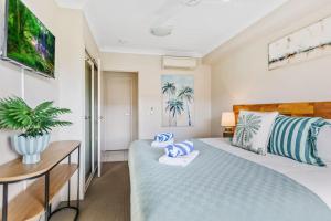 een slaapkamer met een bed en een bureau in een kamer bij Cairns 2BR Palms Stay Top Floor & Pool View in Westcourt +48 foto's