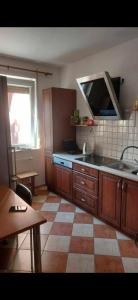 a kitchen with wooden cabinets and a tiled floor at Nocleg Jakubskie Przedmieście in Toruń