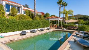 a swimming pool with lounge chairs and a house at Two Estates w Pools Hot Tubs Game Rooms Valley Views Tennis Court Near Beaches Wineries in Elfin Forest