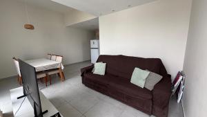 a living room with a brown couch and a table at Seu conforto em Gravatá-PE, com piscina aquecida in Gravatá