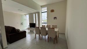 a living room with a dining room table and chairs at Seu conforto em Gravatá-PE, com piscina aquecida in Gravatá