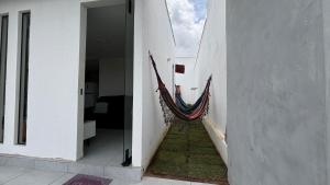 a hallway with a hammock on the side of a building at Seu conforto em Gravatá-PE, com piscina aquecida in Gravatá