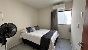 a small bedroom with a bed and a fan at Seu conforto em Gravatá-PE, com piscina aquecida in Gravatá +17 photos