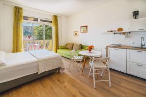 a bedroom with a bed and a kitchen and a table at Studio Apartments Cavrak with Terrace in Baška