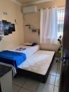 two beds in a small room with a window at Condomínio Royal Park - bairro Coqueiro in Ananindeua