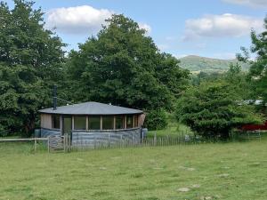 a building with a tent in a field at Sparrow Hill Orchard in Colwall