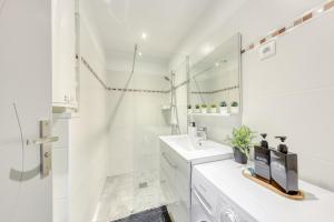 un bagno bianco con lavandino e specchio di Central 2 - 10min Paris - 30min Disneyland -Free Parking a Fontenay-sous-Bois Altre 28 foto