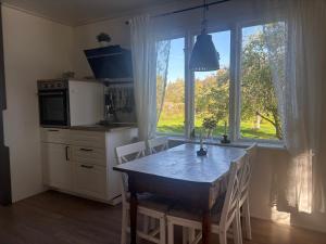 a kitchen with a table and a large window at Hus Brobacka in Rya-Backgården