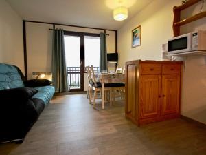 un soggiorno con un divano e una cucina con un tavolo di Studio avec parking couvert à Chamrousse - FR-1-340-61 a Chamrousse