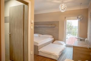 a small bedroom with two beds and a balcony at Garni Hotel Krško in Leskovec pri Krškem
