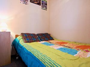 a bedroom with a bed with a colorful comforter and pillows at Studio cabine cosy, 4 pers, balcon sud, au pied des pistes – Chamrousse 1750 - FR-1-340-106 in Chamrousse